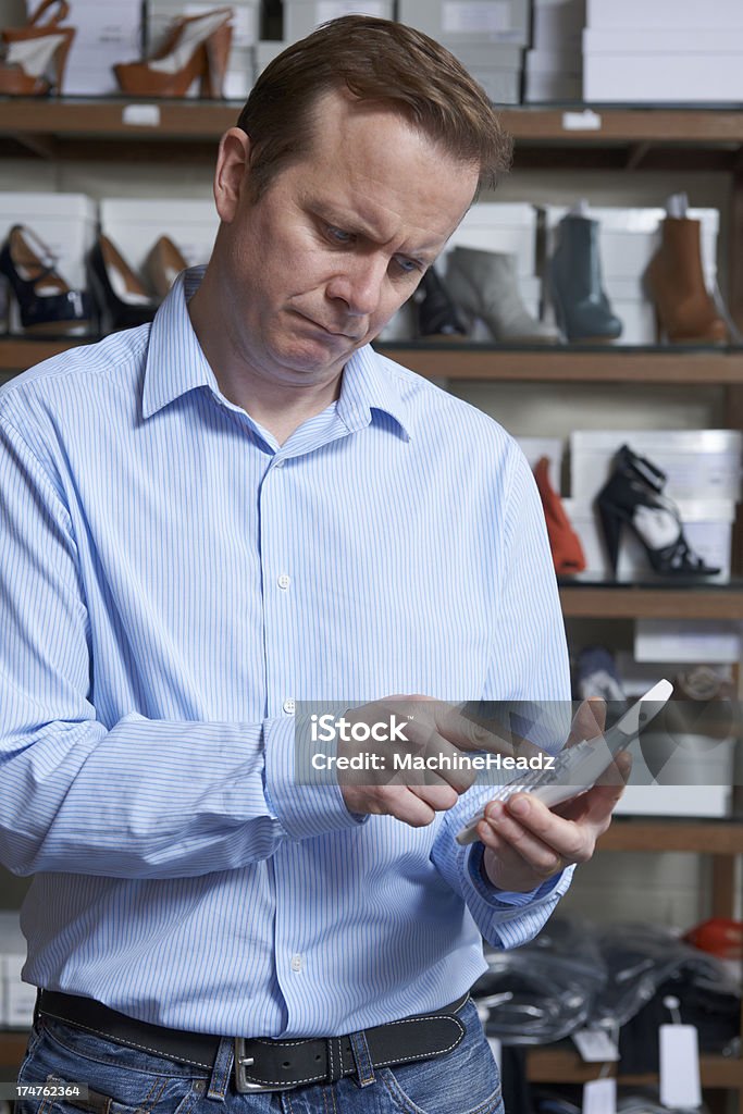 Preocupado proprietário da loja de sapatos com Calculadora - Foto de stock de Dono royalty-free