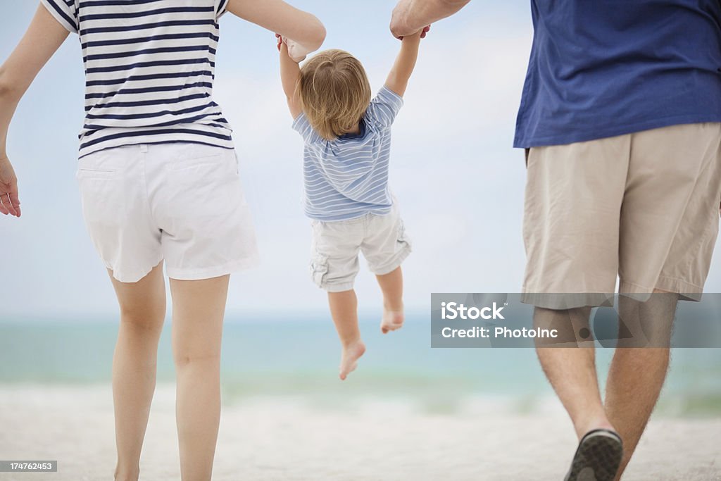 Genitori fiore piccolo ragazzo in spiaggia - Foto stock royalty-free di 30-34 anni