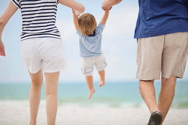 istock Parents Swinging Little Boy At Beach 174762453