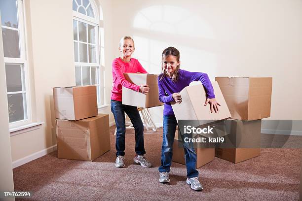 Foto de Duas Meninas Ajudar A Mover As Caixas De Seleção e mais fotos de stock de Caixa - Recipiente - Caixa - Recipiente, Criança, Relocar