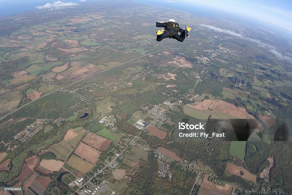 Skydiver in freefall - skydive A skydiver falling over farmland, shot with a fisheye lens. Adventure Stock Photo