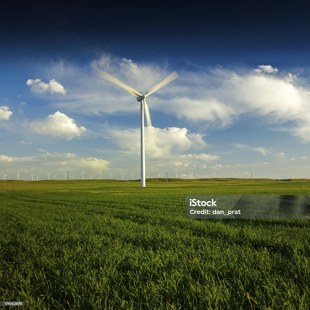 Wind Turbine A wind turbine standing in  a green field, many more turbines in the distance. Carbon Neutrality Stock Photo