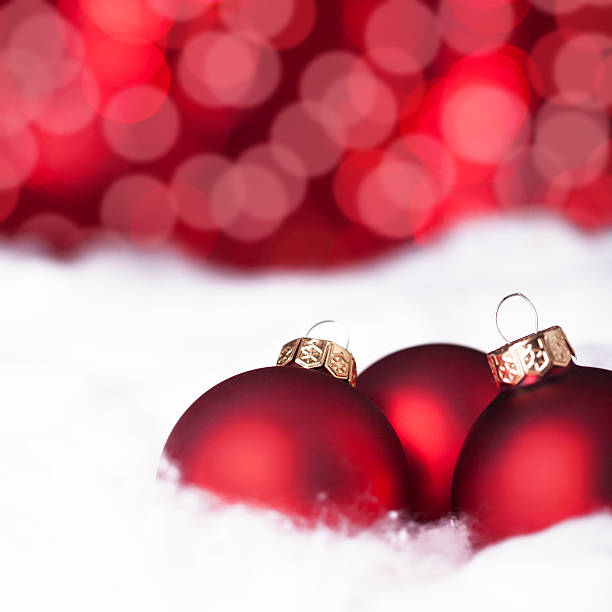 rote weihnachts-kugeln im schnee - marko skrbic stock-fotos und bilder