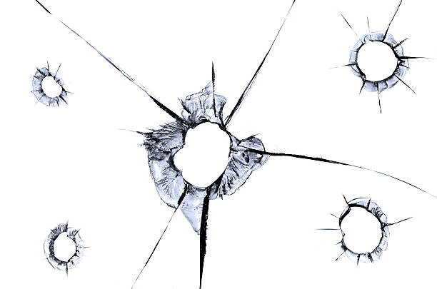 Close up shot of a bullet hole on within the passenger side door of a red car.