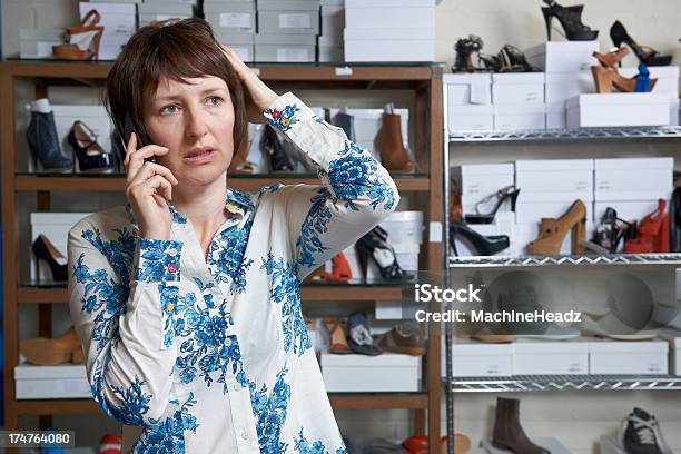 Preocupado Dono De Loja De Sapato Na Telefone - Fotografias de stock e mais imagens de Preocupado - Preocupado, A usar um telefone, Comércio - Ocupação