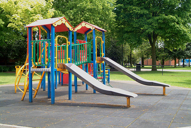 istock Two slides on childrens playground in park with trees 174764317