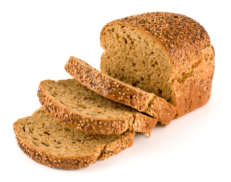 Multi seeded sliced loaf of bread on a white background.