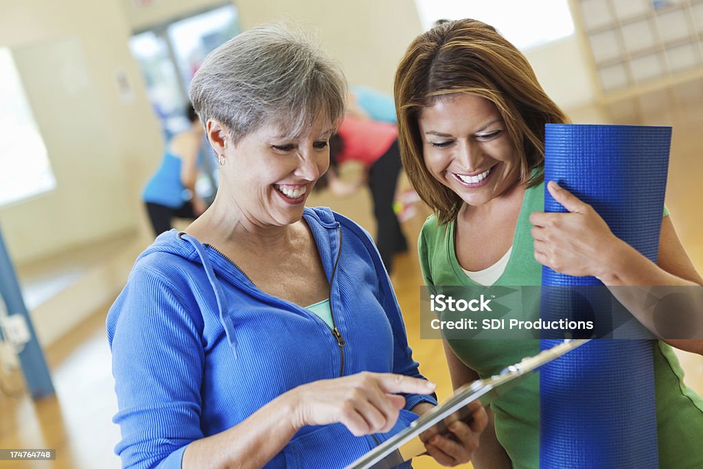 Starszy Instruktor fitnessu Logowanie nowego ucznia do zajęć fizycznych - Zbiór zdjęć royalty-free (Aktywni seniorzy)