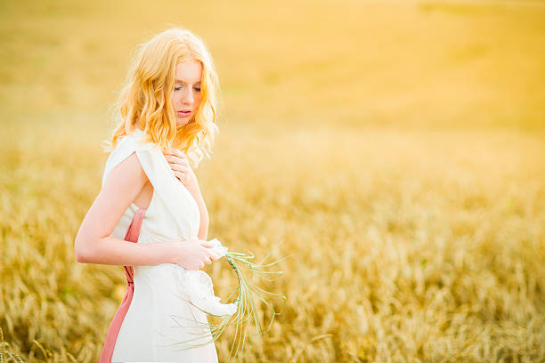 istock Young woman walking in wheat field 174765655