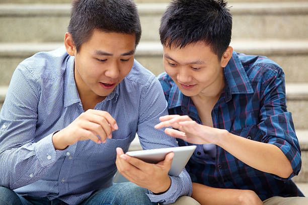 istock picture of happy young men using tablet together 174766040