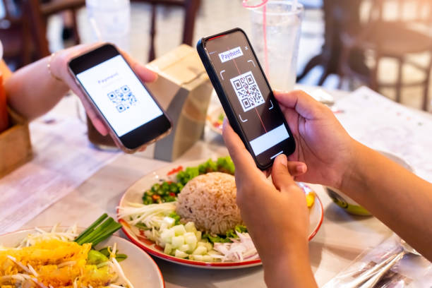 istock Hand using smart phone to scan simulate QR code on tag with blurry Thai food in cafe or restaurant to accepted generate digital pay without money. 1747667477