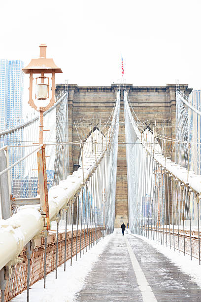 Brooklyn Bridge at winter Brooklyn Bridge tower and a pathway covered in snow during winter brooklyn bridge photos stock pictures, royalty-free photos & images