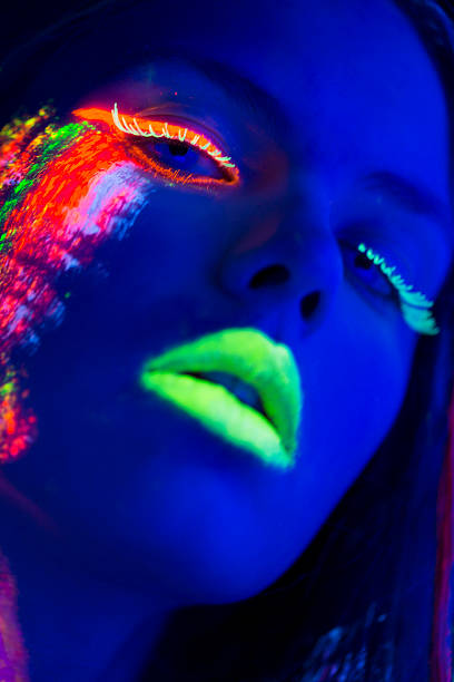 istock Women Portrait with Glowing Multi Colored makeup in black light 174768350