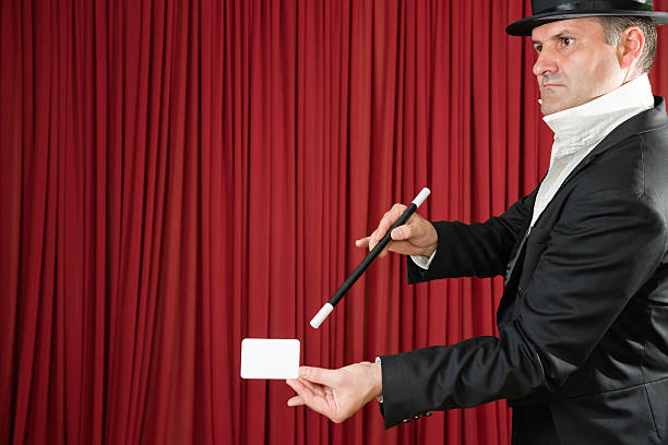 istock Magician on stage doing trick with card 174768479