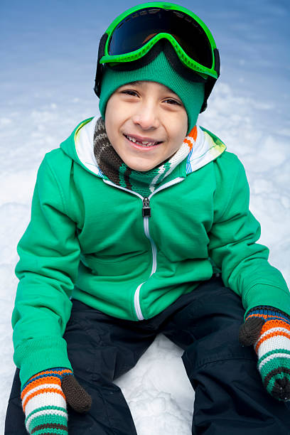 istock Smiling boy snowboarder sitting on snow 174768881