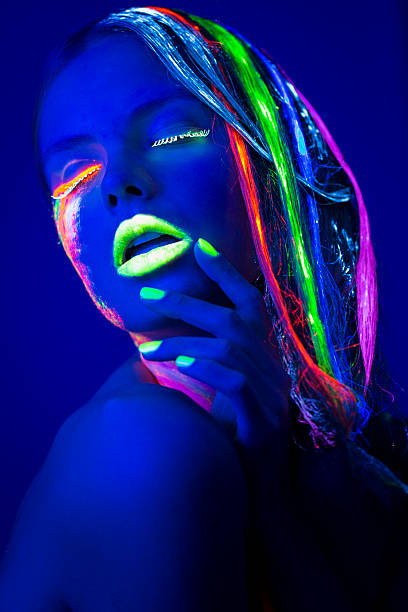 istock Women Portrait with Glowing Multi Colored makeup in black light 174769111