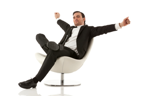Businessman sitting on a chair and stretching arms