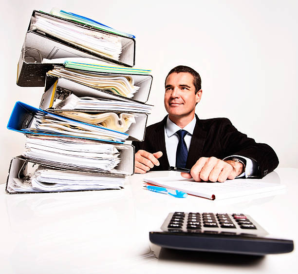 istock Businessman smiles at stack of files, confident he can cope 174769697