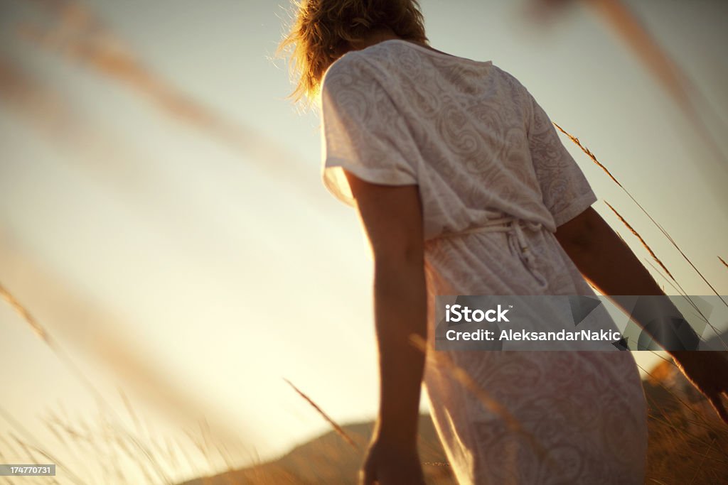 Walking in nature Young woman walking in nature on a beautiful sunny day Adult Stock Photo