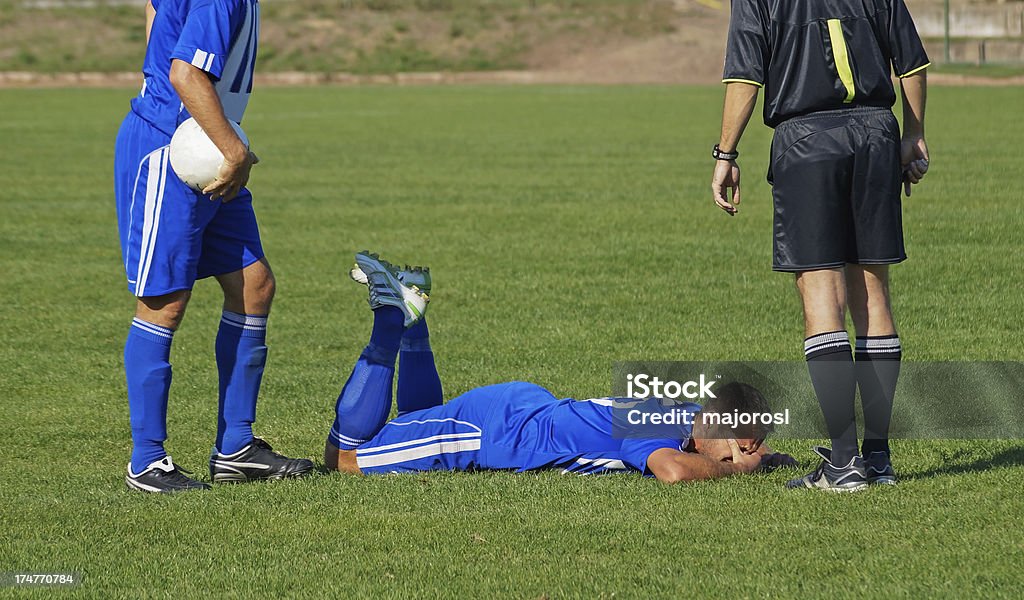 two soccer players and a referee "two soccer players and a referee(photo was taken at an amateur soccer match, not a named soccer team or soccer club)" Lying Down Stock Photo