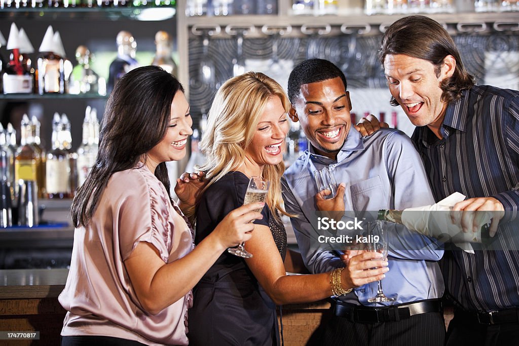 Deux couples au bar accompagné de champagne - Photo de Champagne libre de droits