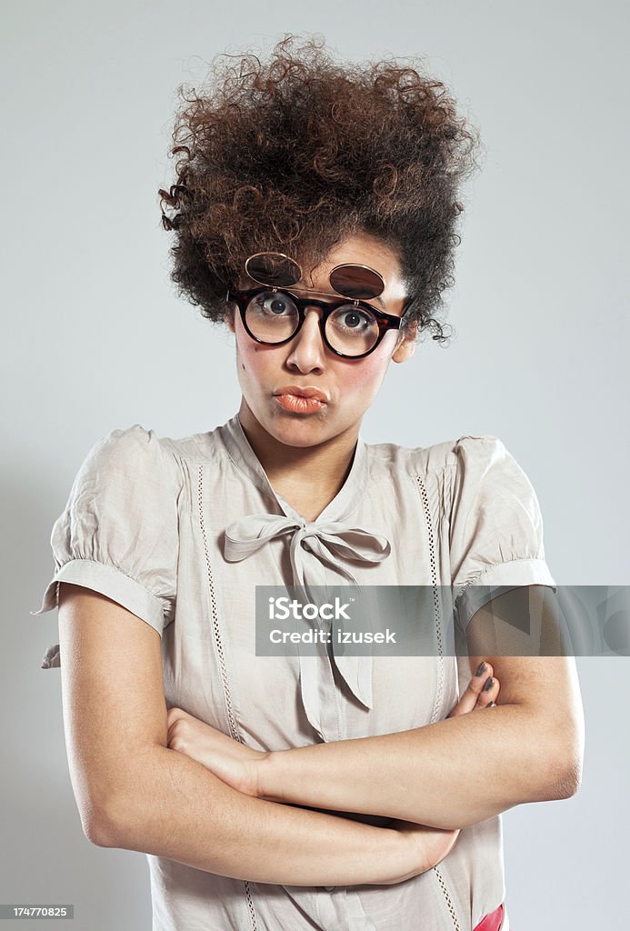 Irritation Portrait of teenaged afro girl wearing funny glasses and staring at camera. Studio shot, grey background. 18-19 Years Stock Photo