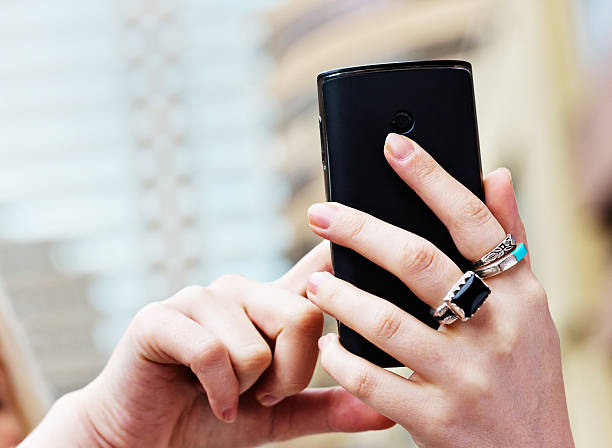 istock Feminine hands using smart phone outside city buildings 174770879