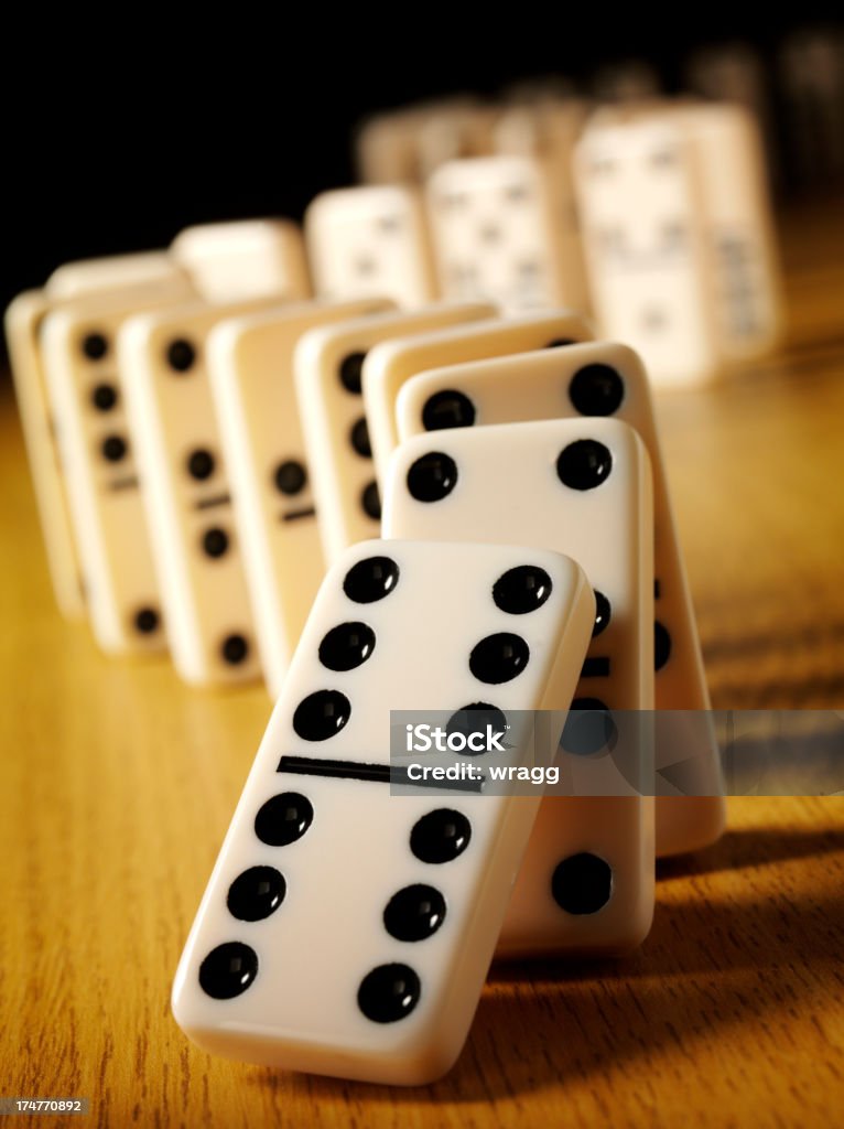 Number Six on a Domino Effect Dominoes with the domino effect on a wooden background. Differential focus.Click on the link below to see more of my business and leisure game images. Backgrounds Stock Photo