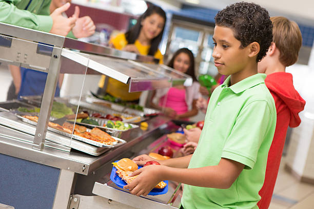 studenti delle scuole secondarie di ottenere i piatti del pranzo nella caffetteria linea - child food school children eating foto e immagini stock