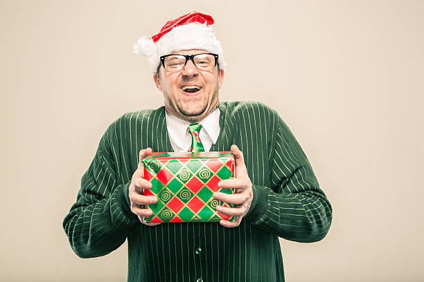 istock delighted Nerdy Christmas Man holding wrapped holiday gift 174771257
