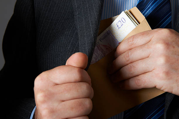 istock Businessman Putting Envelope Of Sterling Notes In Jacket Pocket 174771371