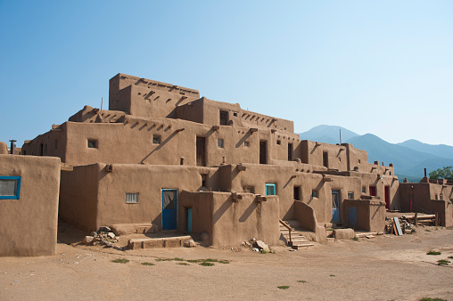 The Taos Pueblo is probably considered one of the world's first apartment buildings.  Dating back about 1,000 years, these pueblos were once only accessible through holes in the roof.  There is still no electricity or running water in these buildings, and the exteriors are replastered with adobe each year.