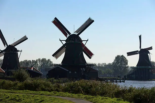 Photo of collection of historic windmills in a row at Zaanse Schans