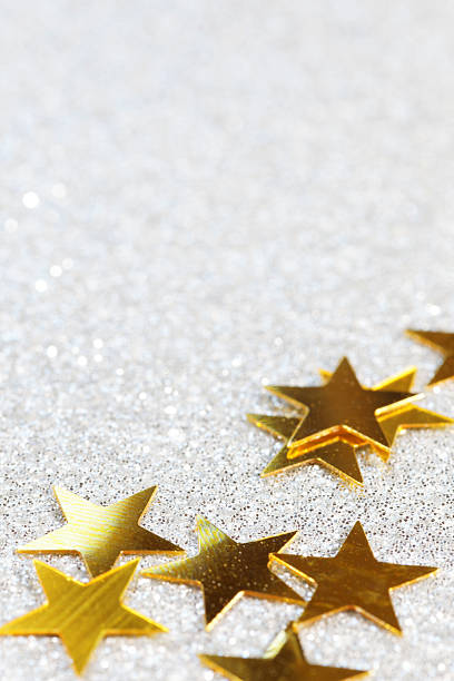 istock golden stars on silver glittering background 174772131