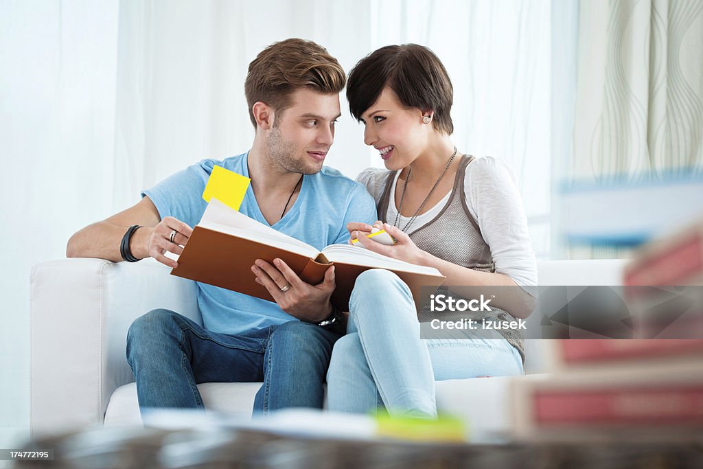 Young couple learning at home Young couple sitting on sofa at home and learning together. 20-24 Years Stock Photo