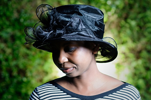An African American Woman Wearing A Smart Black Hat. 