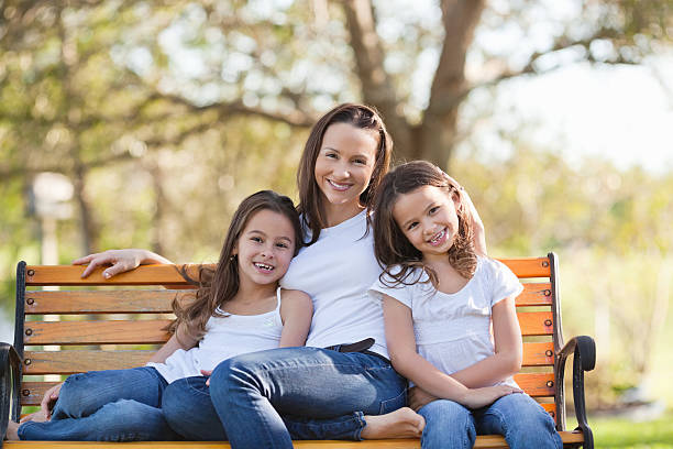 istock Mother With Daughters Sitting On Park Bench 174772499