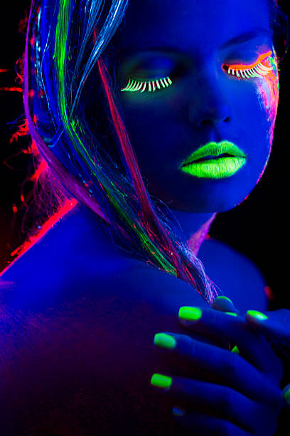 istock Women Portrait with Glowing Multi Colored makeup in black light 174772773