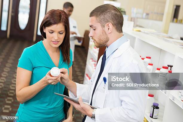 Foto de Farmacêutico Explicar A Dosagem Instructionsof Remédios Ao Cliente Em Farmácia e mais fotos de stock de Adulto