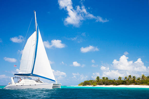 catamaran sailing close by a tropical island in the Caribbean catamaran sailing close by a tropical island in the Caribbean catamaran sailing boats stock pictures, royalty-free photos & images