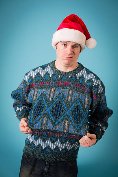 istock Man With Disgusted Look Wearing Santa Hat and Ugly Sweater 174773815