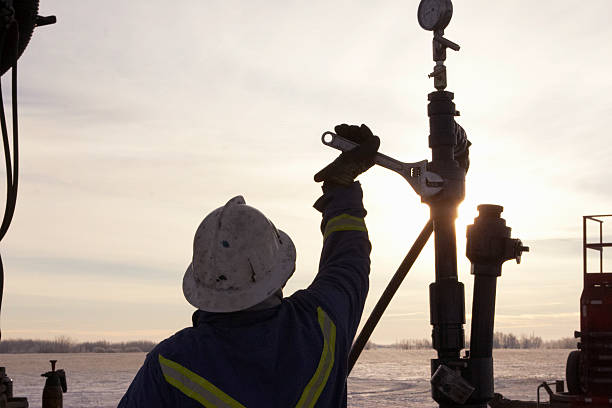 Oil Field Worker at Sunrise Oil Field Worker at Sunrise in the middle of winter air valve photos stock pictures, royalty-free photos & images