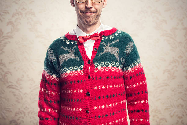Christmas Sweater Nerd "A man in a knit reindeer Christmas cardigan button up sweater, complete with matching red bow tie and a classy mustache.  Damask style vintage wall paper in the background.  Horizontal image." vintage nerd with reindeer sweater stock pictures, royalty-free photos & images