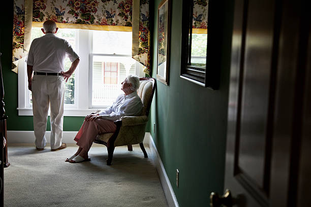 nachdenklich senior paar blick aus fenster - couple senior adult sadness emotional stress stock-fotos und bilder