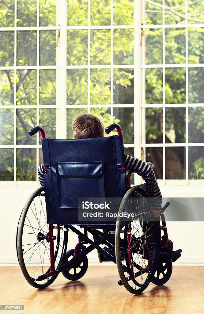 Poignant backview de petit garçon en fauteuil roulant en regardant le jardin - Photo de 8-9 ans libre de droits