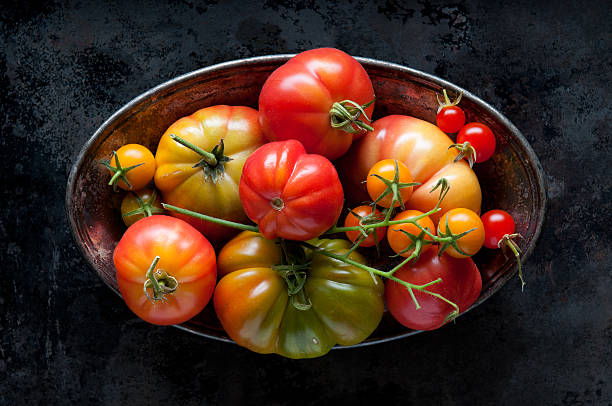 tomate heirloom en un tazón manchado - plate dishware stack multi colored fotografías e imágenes de stock