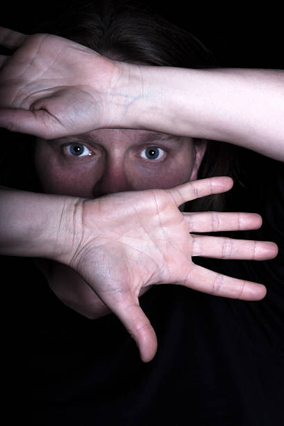 istock Female face covered with her hands in dark, copy space 174776277