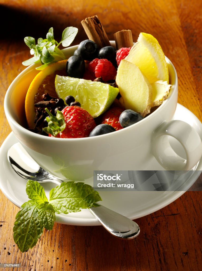 Tea Cup of Fresh Fruits "A white tea cup filled with fresh fruits, which you might find in herbal teas, all on a rustic oak table. To see more of my baking and drinks images, click the link below." Afternoon Tea Stock Photo