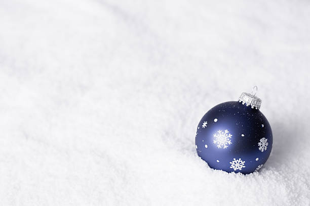 Blue Snowflake Christmas Ornament on Snowy White Background