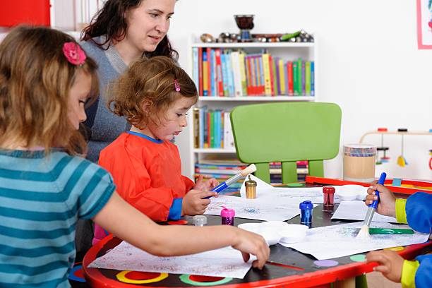 istock Little Children Using Glue To Create Art With Carer 174777200